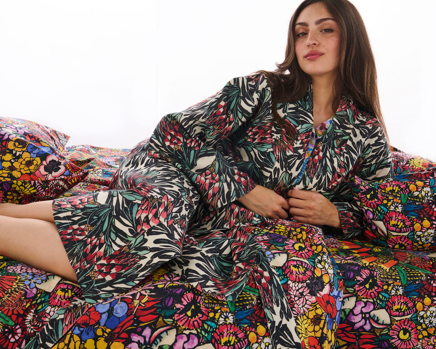 Woman wearing a colorful floral robe on a white background