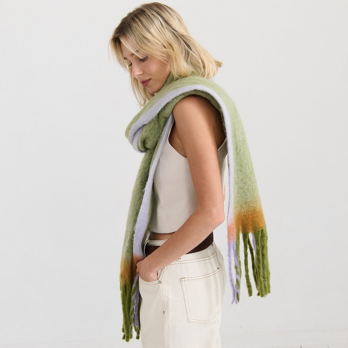 Woman wearing a green scarf with colourful fringe