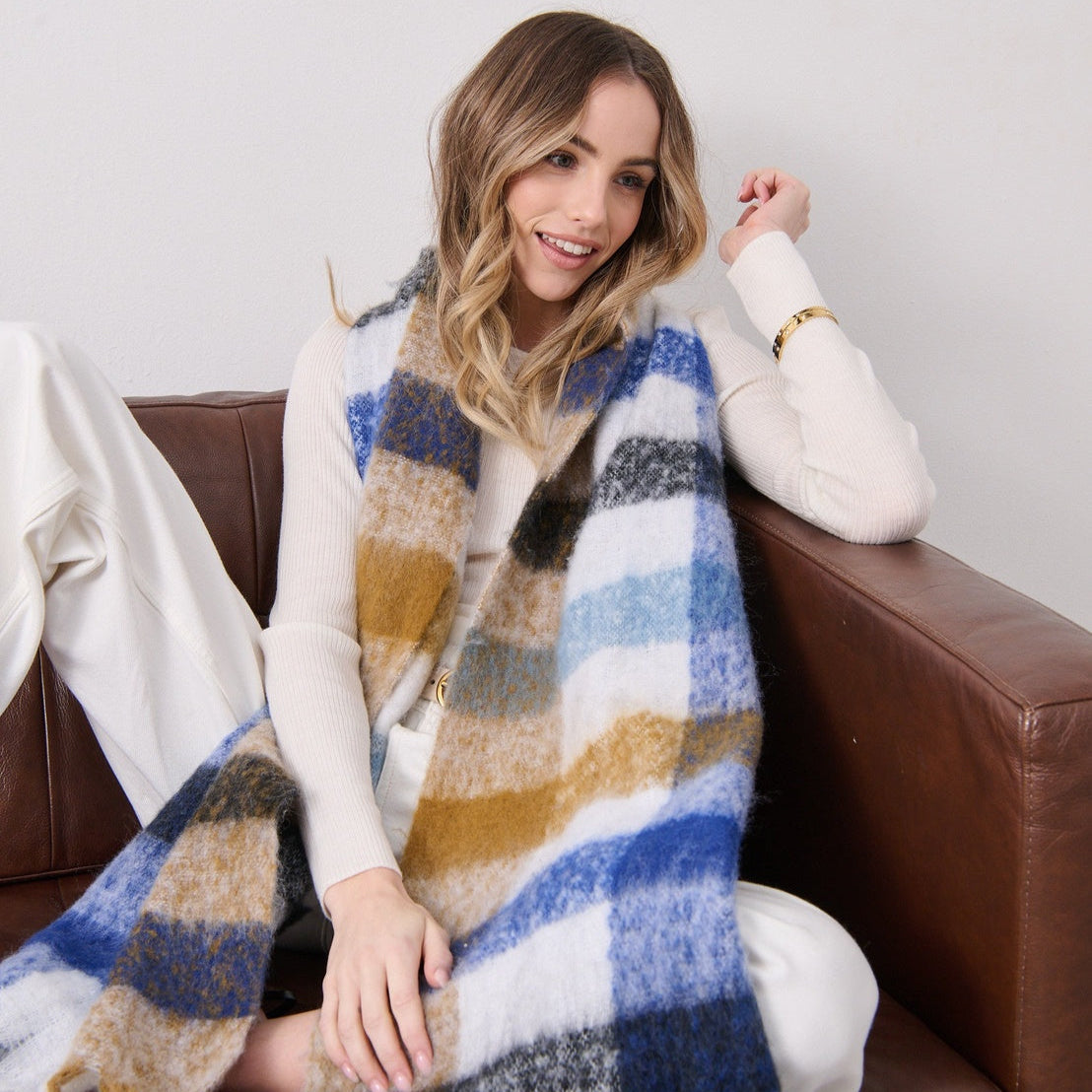 Woman wearing a plaid scarf sitting on a couch